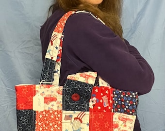 May include: A red, white, and blue patchwork tote bag with a variety of patriotic designs, including stars, stripes, and gnomes. The bag has a button closure and a single strap.