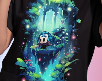 May include: Black t-shirt with a colorful illustration of a character from the video game Hollow Knight. The character is standing on a rock surrounded by glowing plants and a glowing archway in the background.