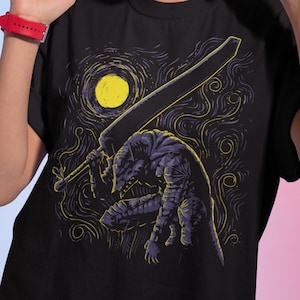 May include: Black t-shirt with a graphic print of a stylized figure holding a sword, inspired by the famous painting "Starry Night" by Vincent van Gogh. The figure is depicted in a dark blue color against a swirling, yellow background.