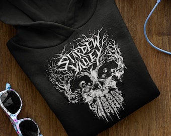 May include: Black hoodie with a white graphic of a skull with trees growing out of it and the text "Stardew Valley".