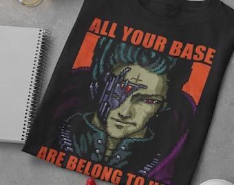 May include: Black t-shirt with a pixelated image of a character from the video game "Zero Wing" and the text "ALL YOUR BASE ARE BELONG TO US".