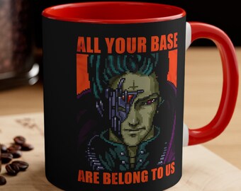 May include: A black and red coffee mug with a pixelated image of a character with green hair and a robotic eye. The text "ALL YOUR BASE ARE BELONG TO US" is printed on the mug.
