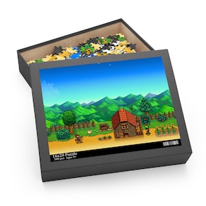 May include: A 500-piece jigsaw puzzle featuring a pixelated farm scene with a house, mountains, and a character in the foreground. The puzzle box is open, revealing the puzzle pieces inside. The box has the text "16x20 Puzzle 500 pcs Ages 9+"