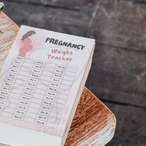 May include: A pink and white pregnancy weight tracker with a cartoon illustration of a pregnant woman. The tracker has a column for each week of pregnancy from week 2 to week 40.