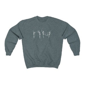 May include: A dark blue sweatshirt with a white graphic of five skeletons dancing. The skeletons are in various poses, including one holding a hoop.