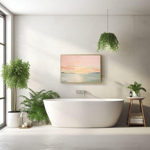 May include: A modern bathroom with a white oval bathtub, a framed landscape painting, and a small wooden side table with towels. Green plants and a hanging plant add a natural touch to the space. The painting depicts a sunset over the water.