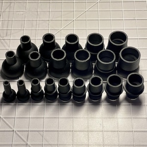 Puede incluir: Una colección de puntas de patas de muebles de goma negra de varios tamaños.