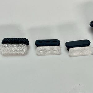 May include: Three clear plastic light covers with black rubber bases. The light covers are translucent and have a textured surface. The rubber bases are solid black.