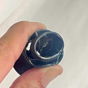 May include: Close-up of a black 3D printed object with a circular opening and a visible internal structure.