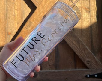 May include: A clear plastic tumbler with a straw, featuring the text "FUTURE Mrs. Pereira" in black and gold lettering.
