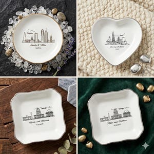 May include: Four white ceramic dishes with silver rims. Each dish features a city skyline design and personalized text. The shapes include a circle, heart, and two square-shaped dishes. The text includes names and dates.