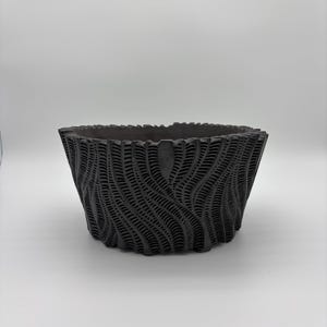 May include: A dark gray, square-shaped planter with a textured, wave-like pattern. The planter has a wide opening and a slightly tapered design. The surface has a series of vertical lines, creating a unique visual texture. The planter is suitable for indoor or outdoor use.