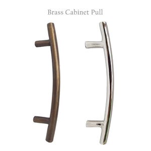 May include: Two cabinet pulls, one in a brushed brass finish and one in a polished nickel finish. Both pulls are curved and have a simple, modern design.