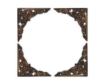 May include: Four ornate gold corner brackets with a floral design.