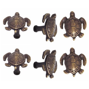 Op de afbeelding: Set van zes antieke messing trekknoppen in de vorm van een schildpad. Elke knop heeft een gedetailleerd schildpadontwerp met een textuur op de schildpad.