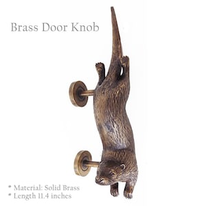 Può includere: Pomo per porta in ottone a forma di lontra, appeso a testa in giù. La lontra è in ottone massiccio e misura 29 cm di lunghezza.