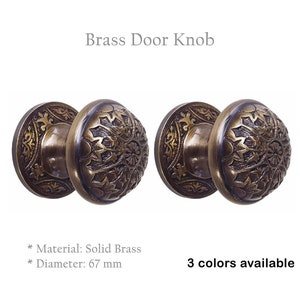 May include: Two antique brass door knobs with intricate floral designs. The knobs are 67 mm in diameter and made of solid brass.