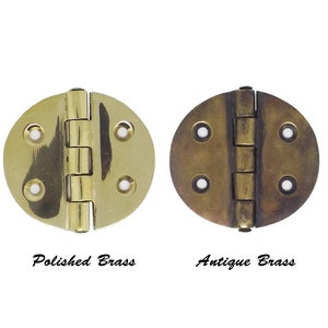 May include: Two round brass hinges, one polished and one antique. The hinges are closed and have four holes on each side.