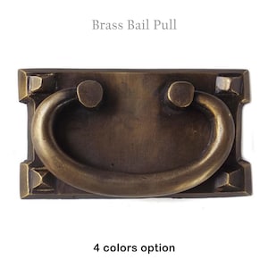 May include: Brass bail pull with a rectangular shape and a curved handle. The pull has a slightly aged, antique finish.  4 colors option.