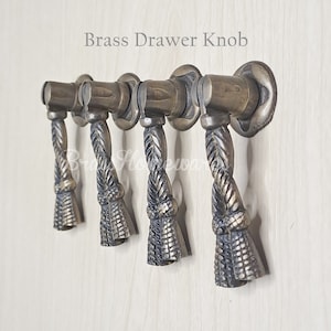 Pode incluir: Cinco puxadores de gaveta de latão antigo com um design de corda e um detalhe de borla. Puxador de gaveta de latão.