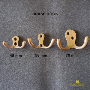 May include: Three brass double hooks in different sizes: 45 mm, 58 mm, and 70 mm. The hooks are all made of solid brass and have a polished finish.