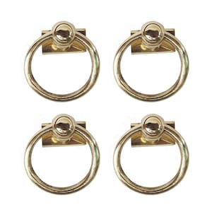 May include: Four gold-toned ring door handles with a round knob on top. Each handle has a rectangular plate.