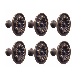 May include: Six antique brass cabinet knobs with a floral design. Each knob has a round base and a short stem.