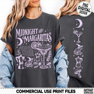 May include: A charcoal gray t-shirt featuring a light purple graphic design with the text Midnight Margaritas, a cocktail glass, a frog wearing a witch hat, a coffee maker, and a mushroom. The back design shows a vertical column of these icons.