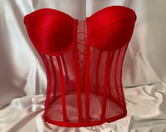 May include: A red mesh corset with a lace-up front and a satin top.