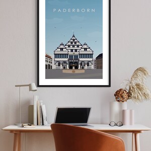 K&ouml;nnte beinhalten: Eine Schwarzwei&szlig;illustration eines Geb&auml;udes mit blauem Himmel im Hintergrund. Das Geb&auml;ude hat ein spitzes Dach und viele Fenster. Der Text "Paderborn" befindet sich oben im Bild.