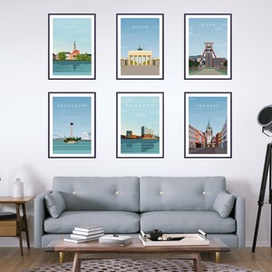 Op de afbeelding: Zes ingelijste prints van stadsgezichten, elk met een andere Duitse stad. De prints zijn gerangschikt in twee rijen van drie, met de naam van de stad bovenaan elk frame. De getoonde steden zijn Kiel, Berlijn, Essen, D&uuml;sseldorf, Hamburg en Freiburg.