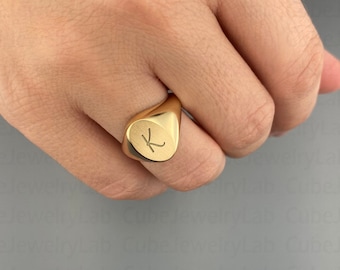 May include: A gold signet ring with the letter "K" engraved on the face.