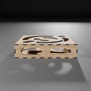 Puede incluir: Una caja de madera con un dise&ntilde;o recortado en forma de espiral. La caja est&aacute; hecha de madera marr&oacute;n claro y tiene un borde marr&oacute;n oscuro.