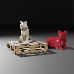 Puede incluir: Una figurita de gato de cer&aacute;mica blanca se sienta en un rascador de gato de madera, mientras que una figurita de gato de cer&aacute;mica roja est&aacute; tumbada en el suelo.
