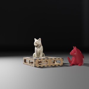 Puede incluir: Dos figuritas de cer&aacute;mica de gatos, una blanca y otra roja, sentadas en una plataforma de madera. El gato blanco est&aacute; sentado en la plataforma, mientras que el gato rojo est&aacute; sentado en el suelo.