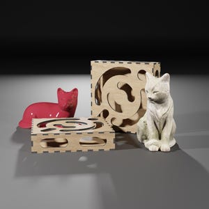 Puede incluir: Dos casas de madera para gatos con un dise&ntilde;o de corte. Una casa es un cubo y la otra es una plataforma plana. Una figurita de gato de cer&aacute;mica roja est&aacute; en la plataforma y una figurita de gato de cer&aacute;mica blanca est&aacute; frente al cubo.