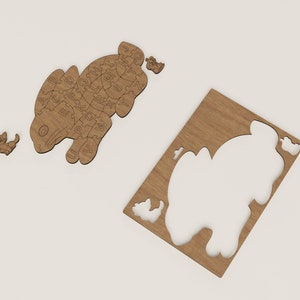 K&ouml;nnte beinhalten: Holzpuzzle eines Kaninchens mit den Buchstaben des Alphabets auf seinem K&ouml;rper. Das Puzzle besteht aus mehreren Teilen, die zusammengef&uuml;gt werden, um das Kaninchen zu bilden. Es gibt auch ein separates Teil, das ein kleineres Kaninchen ist.
