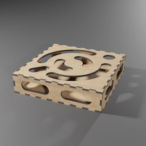 Puede incluir: Una caja de madera con un dise&ntilde;o de corte decorativo. La caja est&aacute; hecha de madera marr&oacute;n claro y tiene un borde marr&oacute;n oscuro.