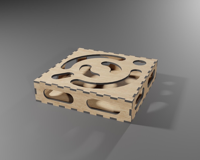 Puede incluir: Una caja de madera con un dise&ntilde;o de corte decorativo. La caja est&aacute; hecha de madera marr&oacute;n claro y tiene un borde marr&oacute;n oscuro.