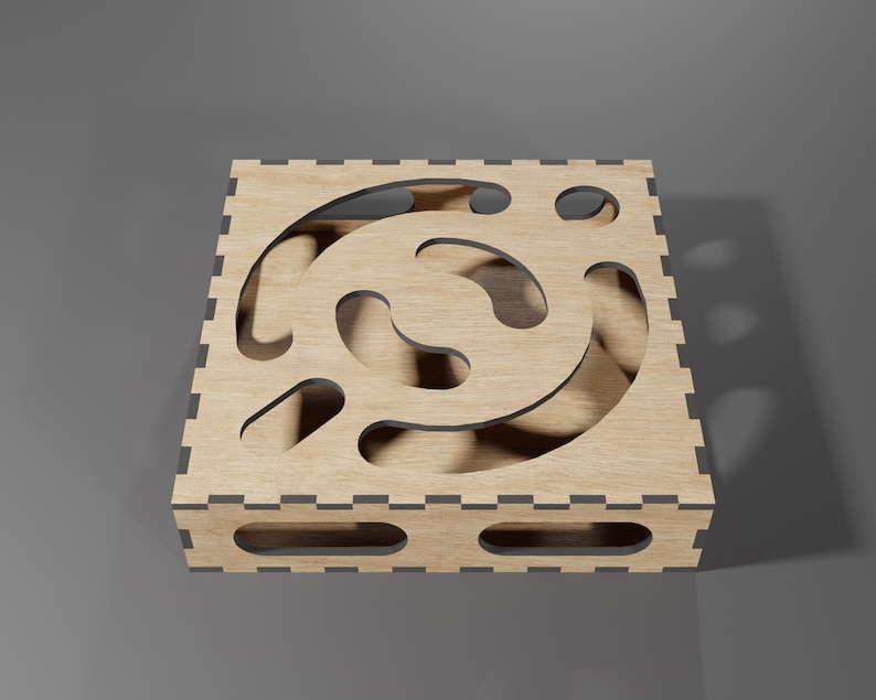 Puede incluir: Una caja de madera con un dise&ntilde;o de corte decorativo. La caja tiene un acabado marr&oacute;n claro y un borde gris oscuro.