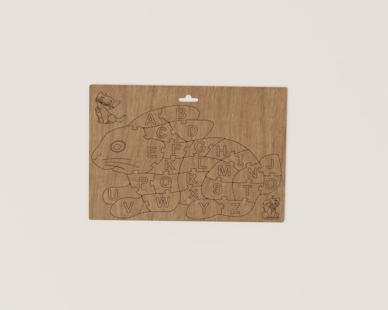 K&ouml;nnte beinhalten: Holzpuzzle in Form eines Fisches mit einer Katze und einem Hund an beiden Enden. Die Puzzleteile sind mit den Buchstaben A bis Z beschriftet.