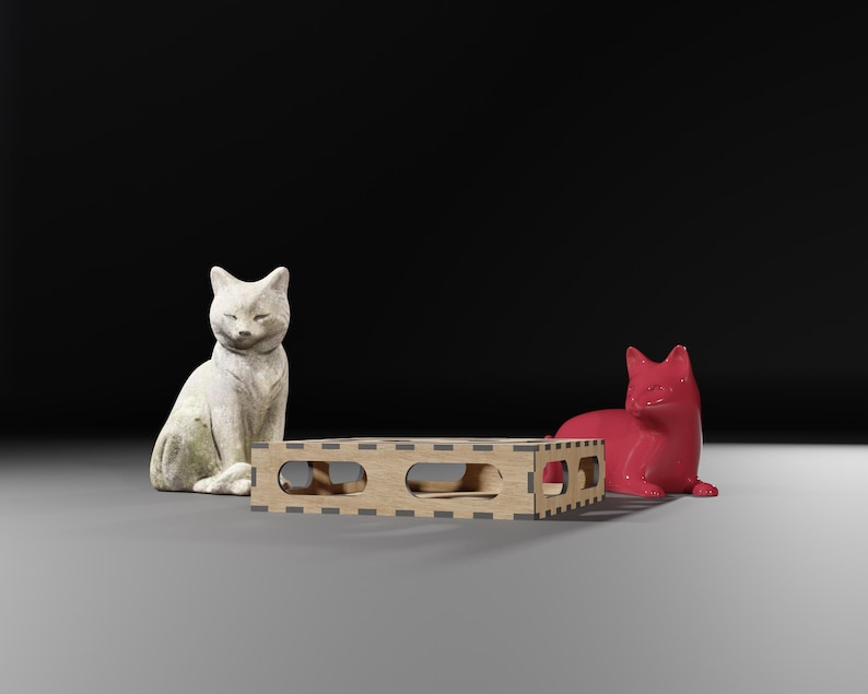 Puede incluir: Una figurita de gato de cer&aacute;mica blanca sentada junto a una figurita de zorro de cer&aacute;mica roja. Ambas figuritas est&aacute;n sobre una plataforma de madera con un dise&ntilde;o de corte.