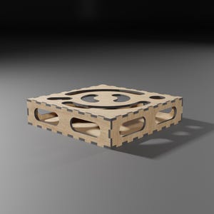 Puede incluir: Una caja de madera con un dise&ntilde;o recortado en el centro. La caja est&aacute; hecha de madera marr&oacute;n claro y tiene un borde marr&oacute;n oscuro.