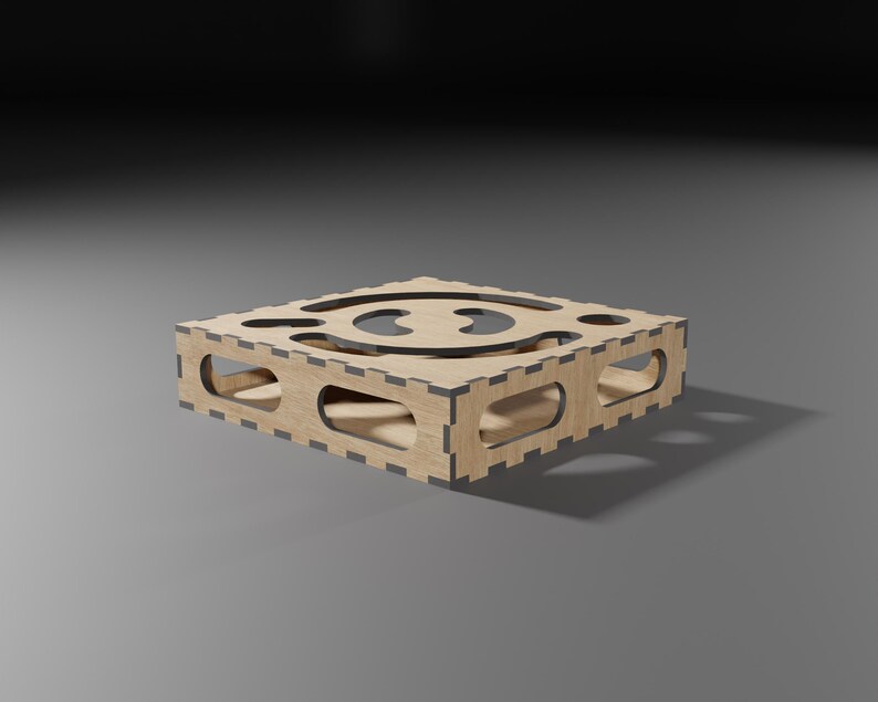 Puede incluir: Una caja de madera con un dise&ntilde;o recortado en el centro. La caja est&aacute; hecha de madera marr&oacute;n claro y tiene un borde marr&oacute;n oscuro.