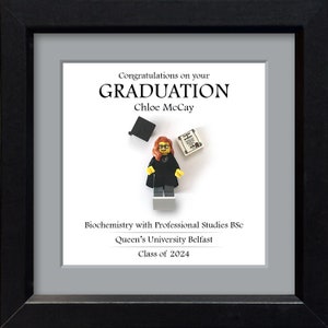 May include: A framed graduation certificate with a Lego figure of a person wearing a graduation cap and gown. The text on the certificate reads "Congratulations on your GRADUATION Chloe McCay Biochemistry with Professional Studies BSc Queen's University Belfast Class of 2024".
