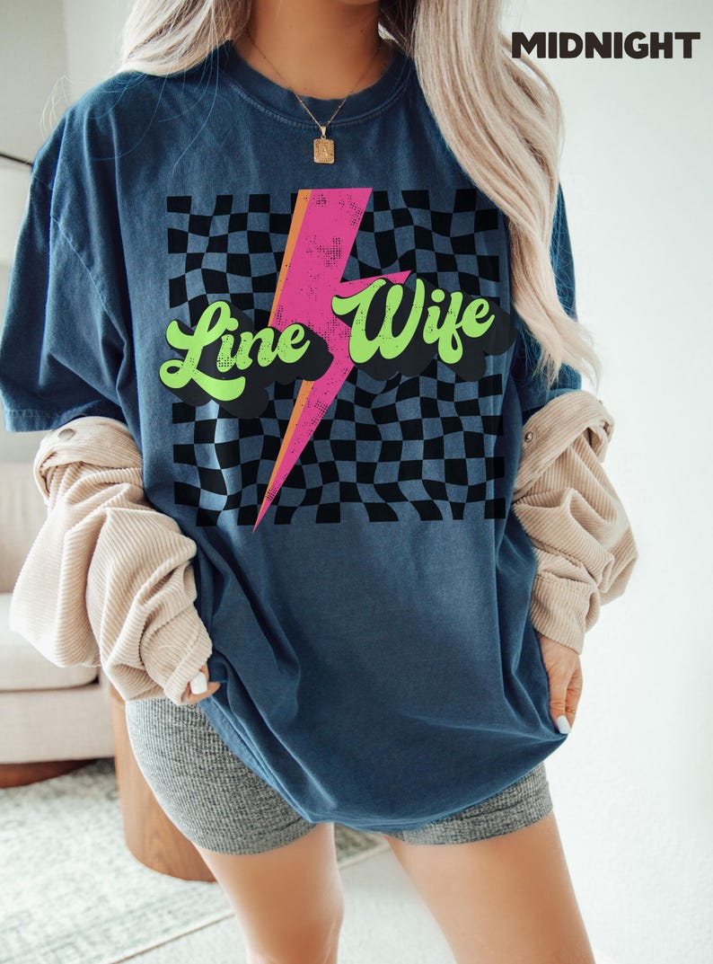 May include: A blue t-shirt with a checkered pattern, a pink lightning bolt, and the text "Line Wife" in green and white lettering.