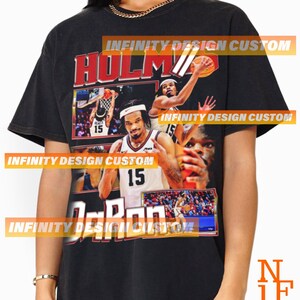 May include: Black t-shirt featuring a basketball player graphic with the name "HOLM" in red and the name "DaRon" in white. The number "15" is visible on the player's jersey. The shirt has a vintage, distressed look.