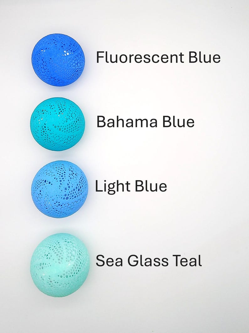 May include: Four round, crocheted, decorative balls in shades of blue and teal. The balls are arranged vertically from top to bottom. The colors are labeled as Fluorescent Blue, Bahama Blue, Light Blue, and Sea Glass Teal.