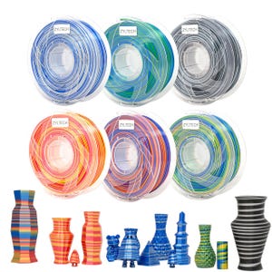 May include: A selection of 3D printer filament spools and decorative vases. The spools are in clear cases and display a range of colours, including blue, green, and orange. The vases are in diverse shapes and colours.