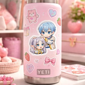 Puede incluir: Una botella de agua Yeti rosa adornada con varias pegatinas. Las pegatinas incluyen ilustraciones de estilo anime de personajes, un oso de peluche rosa, fresas, corazones y un lazo rosa. La botella tiene una base plateada y la marca "YETI" es visible.